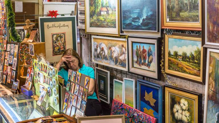 A woman falls asleep at work surrounded by artwork she is selling