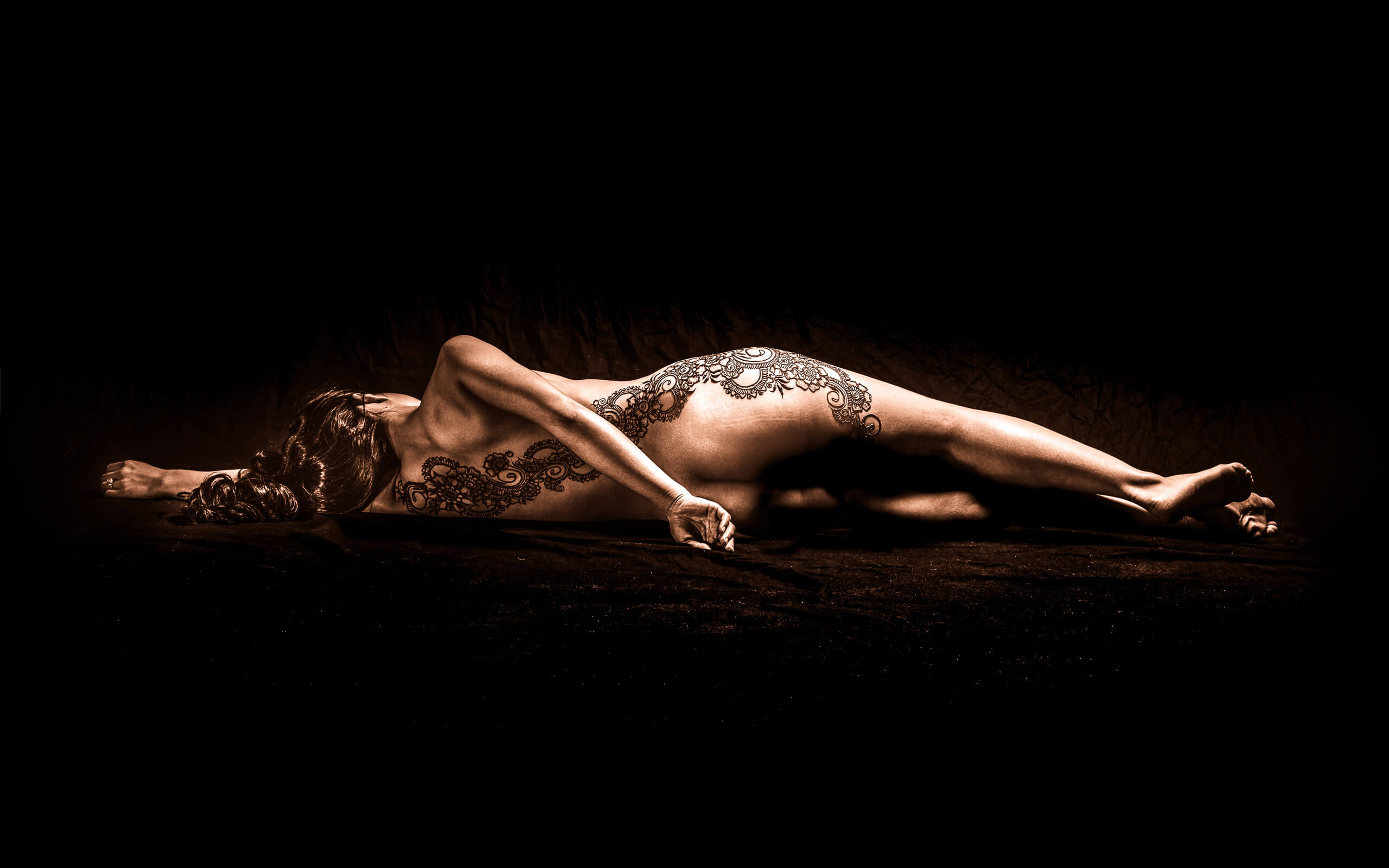 Portrait Photography. Boudoir photography sessions of a nude woman with henna on her back.