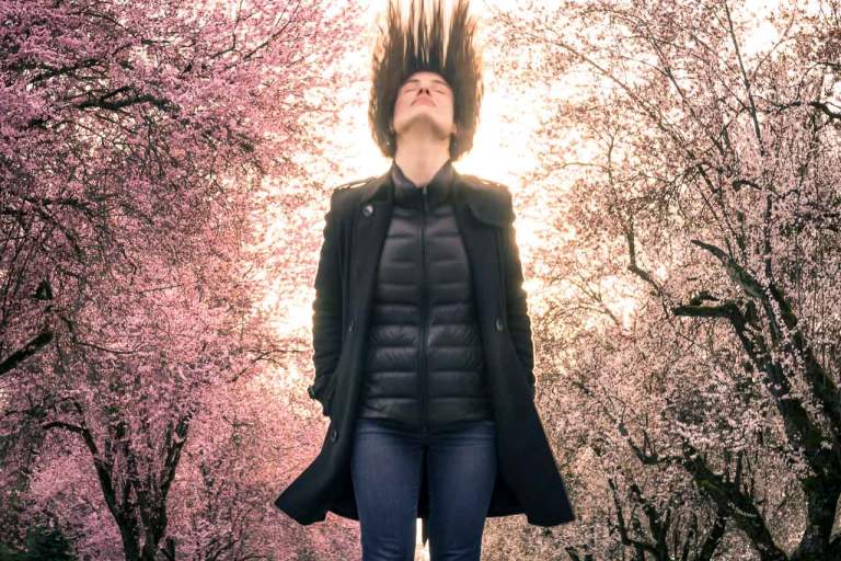 Marketing Image Content. Branding photography featuring a woman in fashion with outerwear surrounded by Sakura