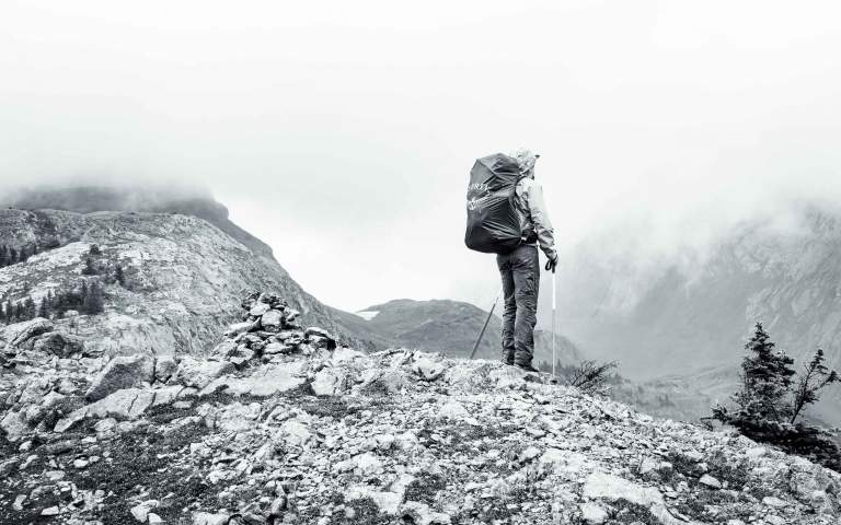 Marketing Image Content. Branding photography featuring a man wearing an Osprey backpack on a mountain top.