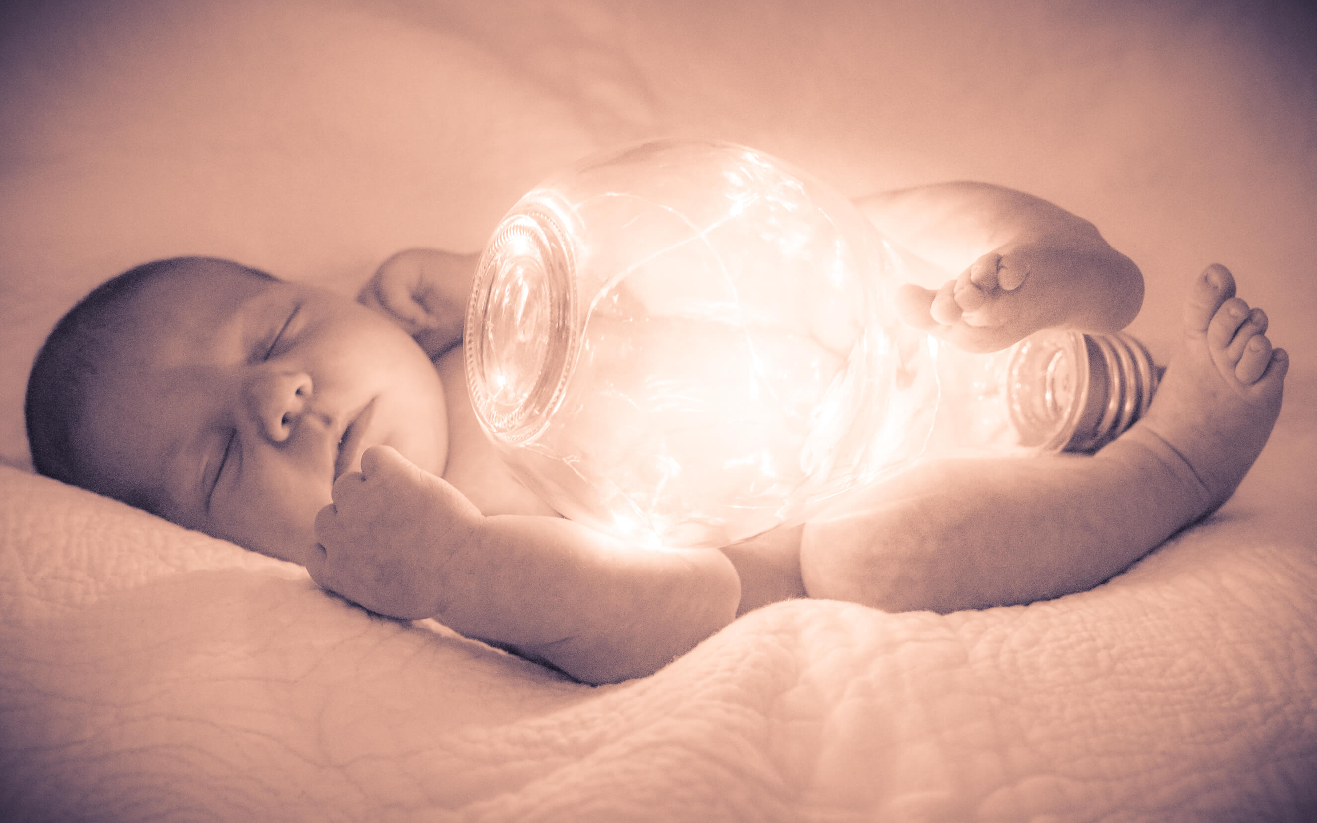 Newborn Photography. An image of a newborn holding a lightbulb