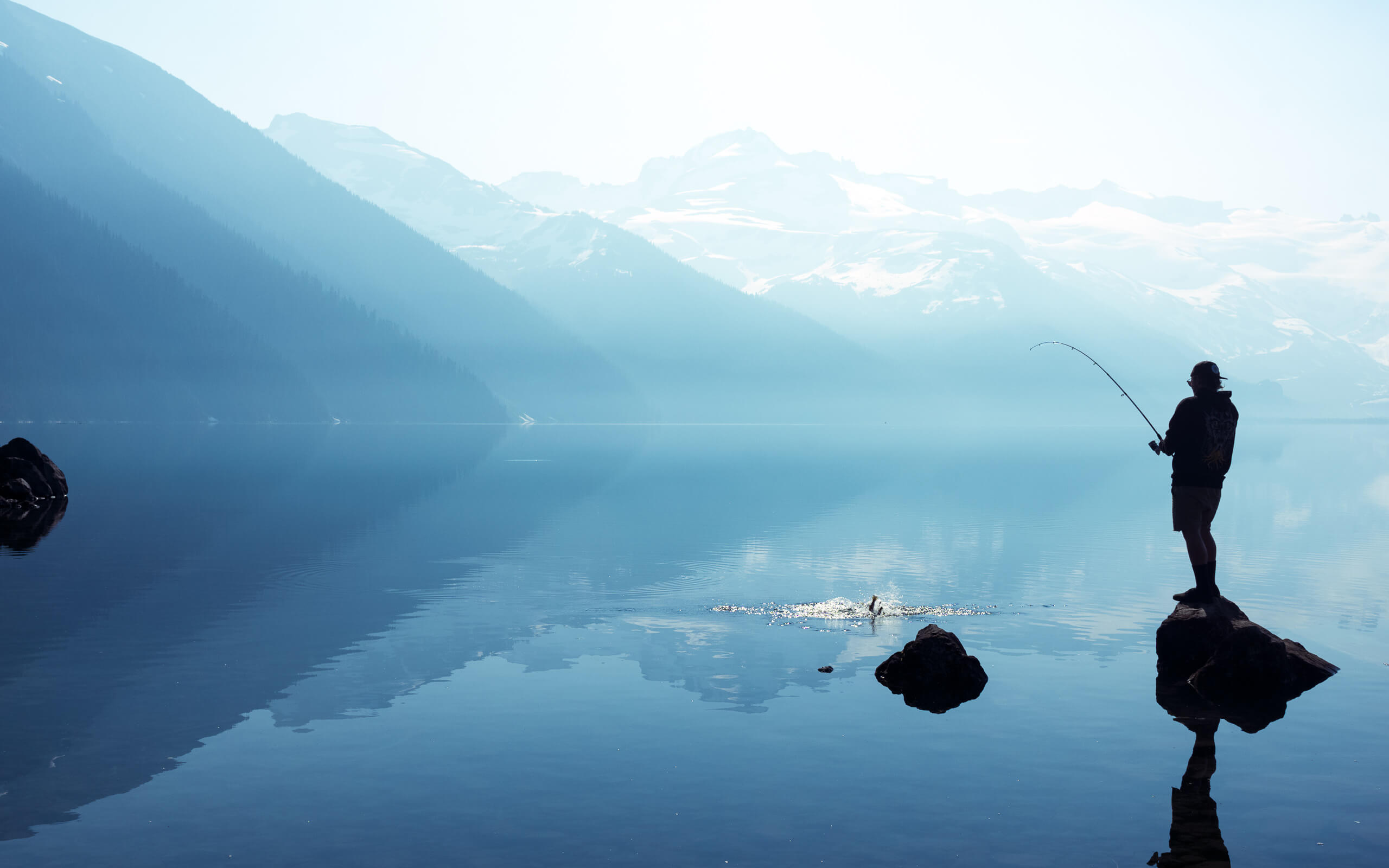 Stock Images Photos. Stock image for sale of a man fishing at Garibaldi Glacial Lake
