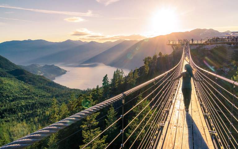 Adventure Photos. Featured LIFELIGHTLENS image of a woman walking across the sea to sky suspension bridge in Squamish